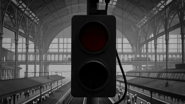 Sinal ferroviário vermelho sob o teto de aço de uma estação.